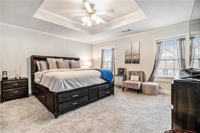 bedroom with light carpet, a tray ceiling, and ceiling fan