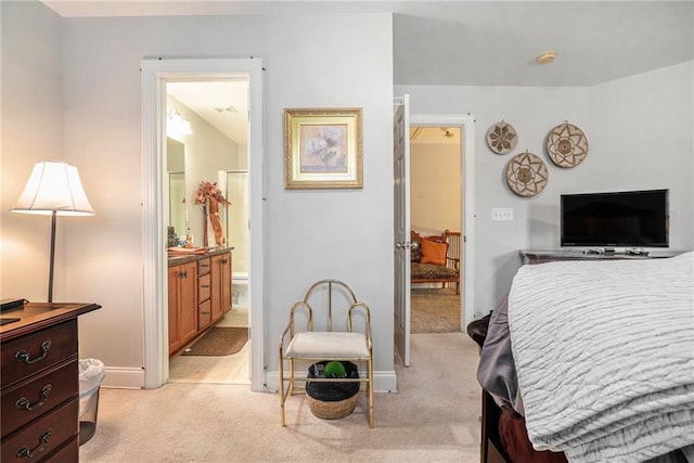 bedroom featuring light carpet and ensuite bath