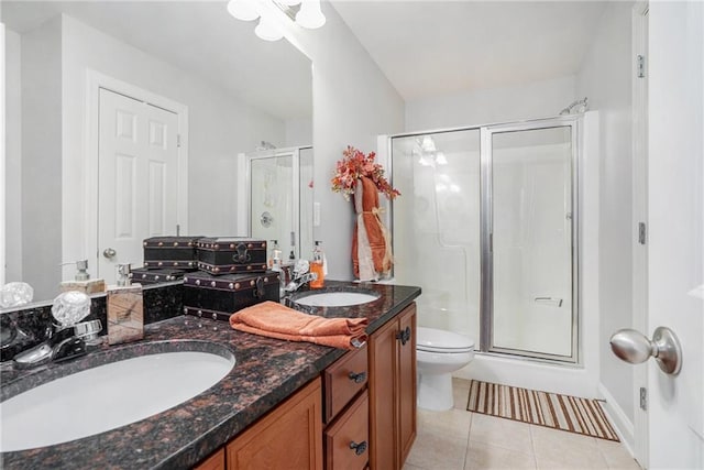 bathroom with tile patterned floors, vanity, an enclosed shower, and toilet