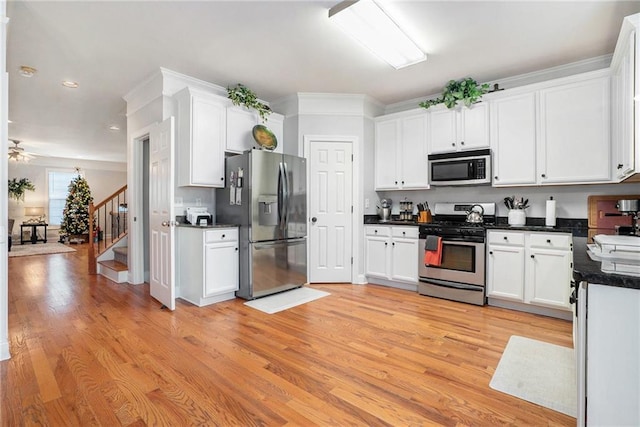 kitchen with white cabinetry, light hardwood / wood-style flooring, ceiling fan, and stainless steel appliances