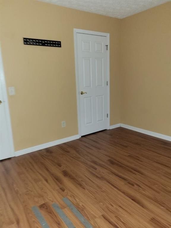 spare room featuring hardwood / wood-style flooring and a textured ceiling