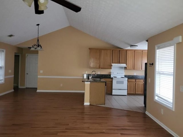 kitchen with electric stove, sink, dark wood-type flooring, black fridge, and decorative light fixtures