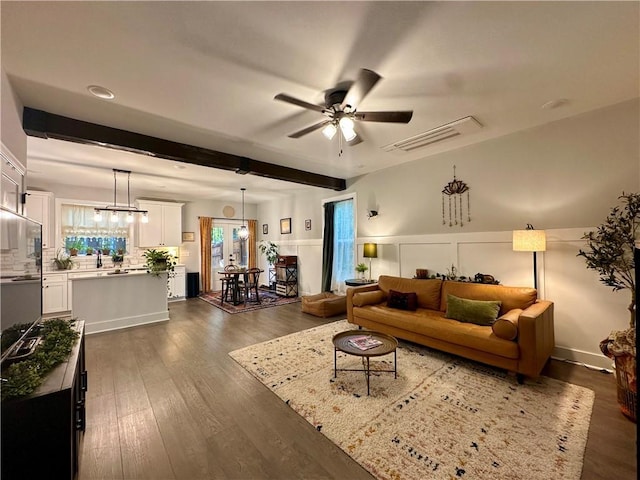 living room with beamed ceiling, dark hardwood / wood-style floors, and ceiling fan