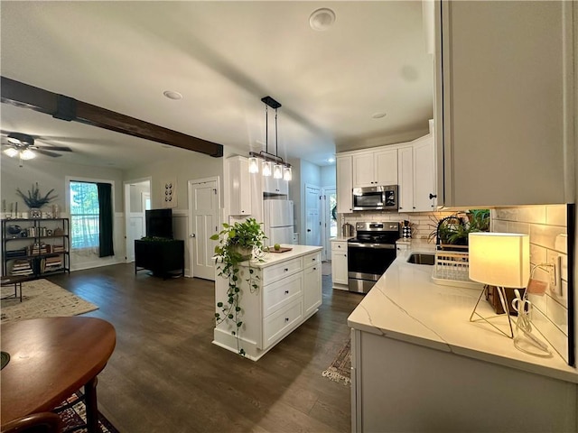 kitchen featuring pendant lighting, dark hardwood / wood-style floors, white cabinetry, and stainless steel appliances