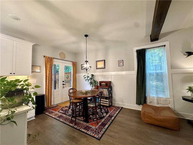 dining room with beamed ceiling and dark wood-type flooring