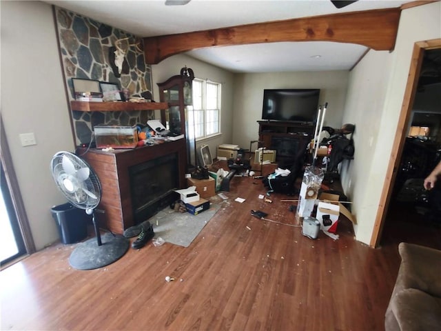 living room featuring hardwood / wood-style flooring, a large fireplace, and beam ceiling