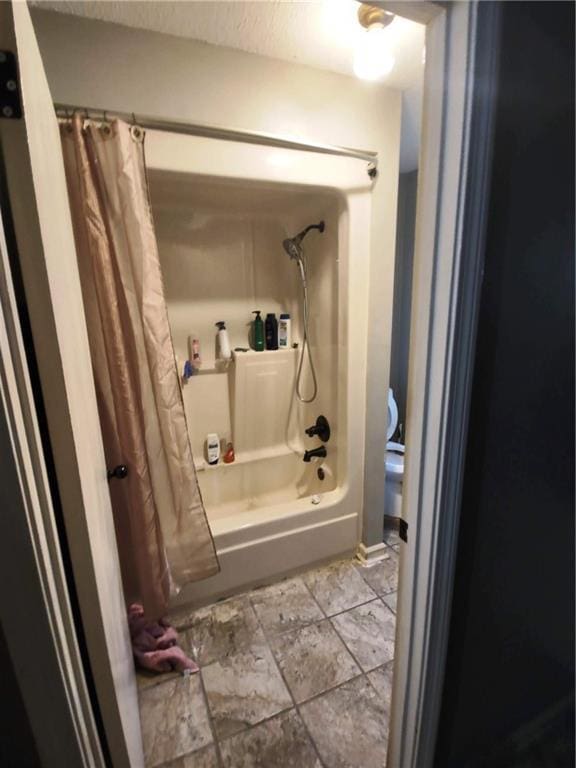 bathroom with shower / bath combo with shower curtain