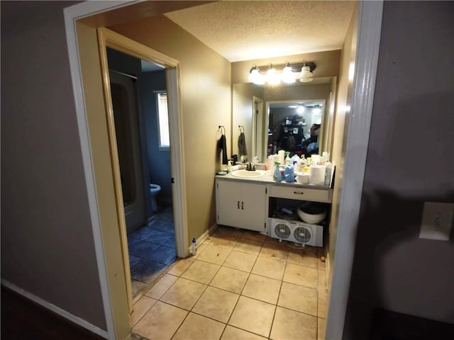 bathroom with vanity, tile patterned floors, toilet, and a textured ceiling