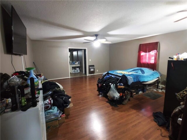 bedroom featuring ceiling fan, dark wood-type flooring, and a textured ceiling