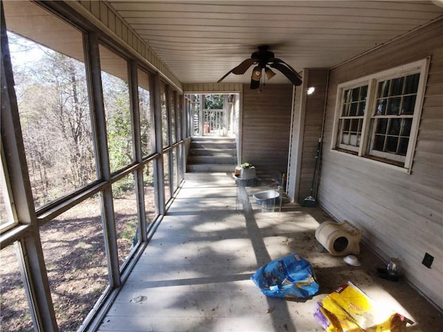 unfurnished sunroom with ceiling fan