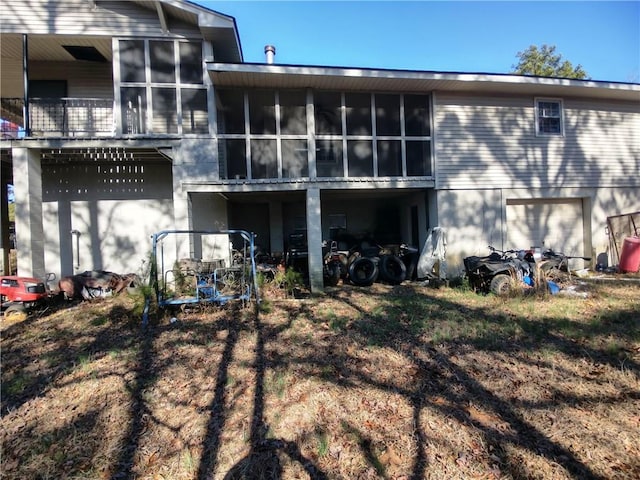 back of property featuring a garage and a sunroom