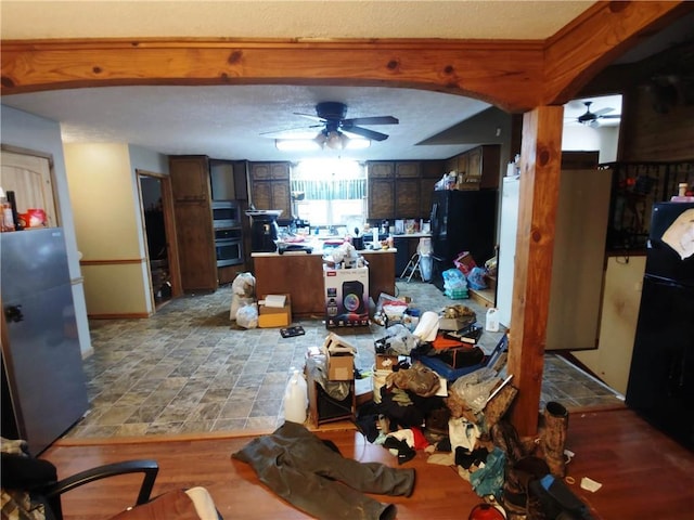 kitchen featuring black fridge, stainless steel oven, refrigerator, and ceiling fan