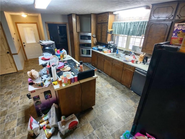 kitchen with sink, a textured ceiling, and black appliances