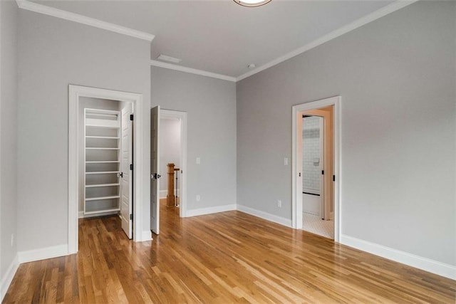 unfurnished bedroom with hardwood / wood-style flooring, ornamental molding, and a closet