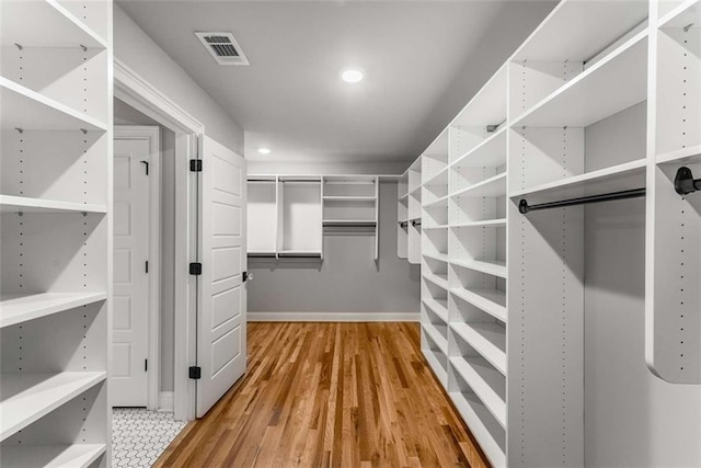 walk in closet with hardwood / wood-style flooring