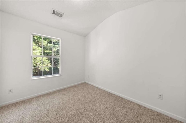 carpeted spare room featuring lofted ceiling