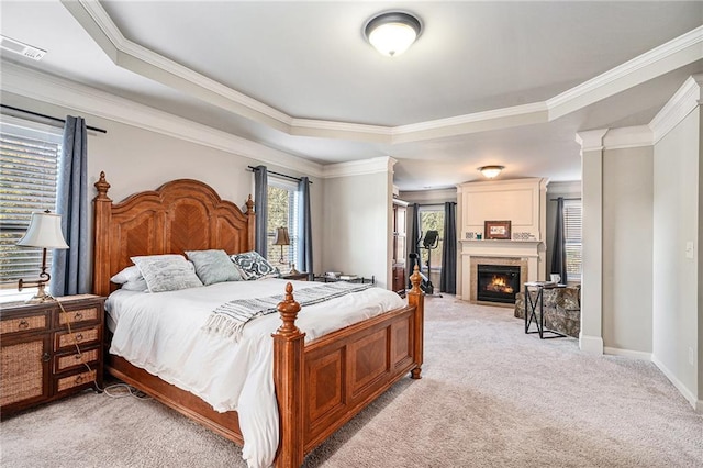 bedroom featuring crown molding, light carpet, and a raised ceiling