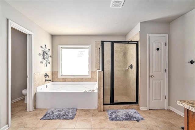 full bathroom featuring vanity, shower with separate bathtub, toilet, and tile patterned flooring