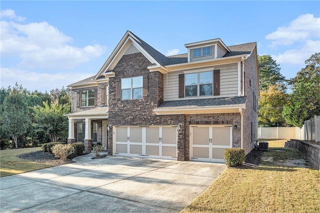 craftsman-style house with a front yard, a garage, and central air condition unit