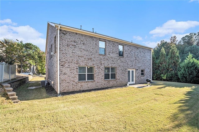 back of house with a yard and central air condition unit