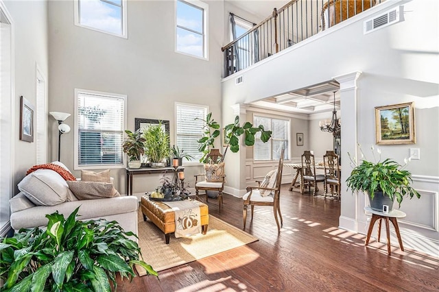 living room featuring dark hardwood / wood-style floors, a chandelier, and a high ceiling