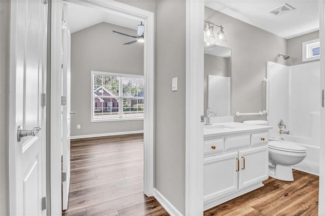 full bathroom with hardwood / wood-style floors, shower / bathing tub combination, vanity, toilet, and a healthy amount of sunlight