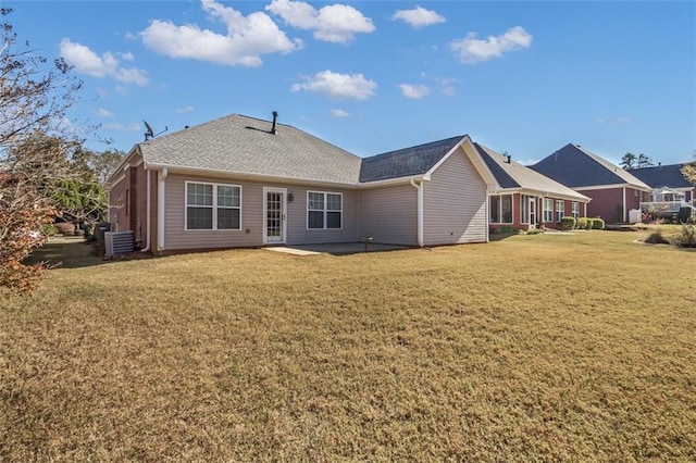 rear view of property with a yard, central AC unit, and a patio area