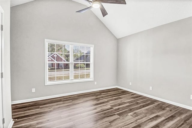 spare room with dark hardwood / wood-style flooring, vaulted ceiling, and ceiling fan