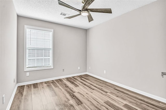 spare room with ceiling fan, a textured ceiling, and light wood-type flooring