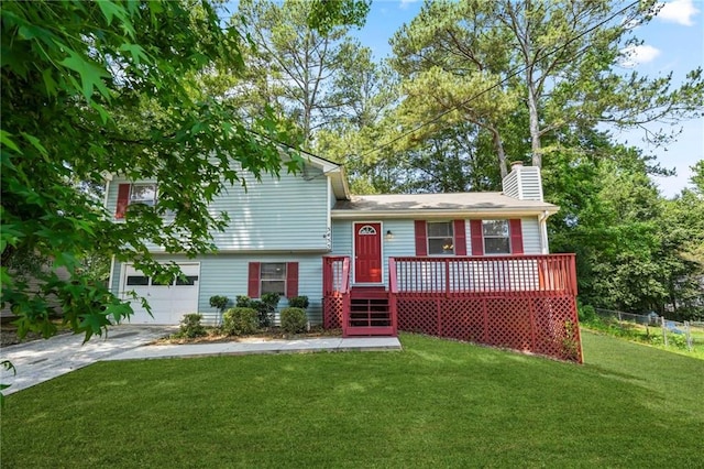 tri-level home featuring a garage, a wooden deck, and a front yard