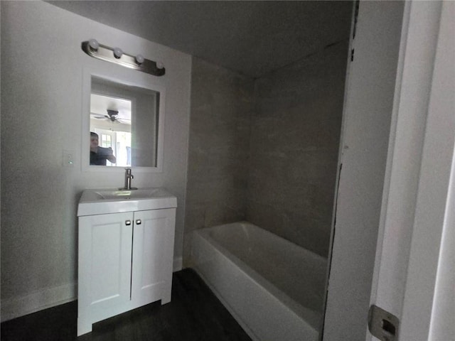 bathroom with ceiling fan, vanity, and a tub