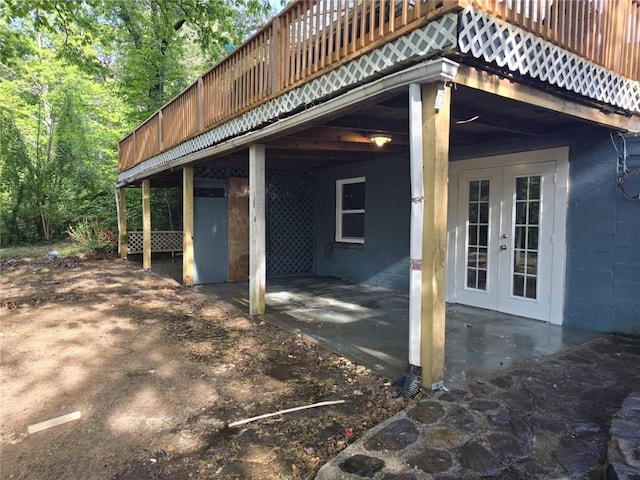 view of side of home featuring french doors, a deck, and a patio area