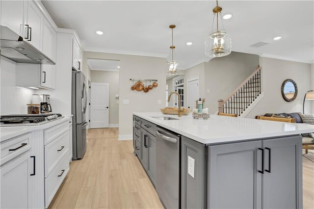 kitchen with white cabinetry, a kitchen breakfast bar, hanging light fixtures, a kitchen island with sink, and stainless steel appliances