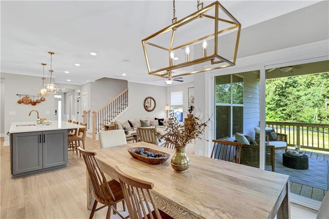 kitchen featuring sink, gray cabinetry, appliances with stainless steel finishes, pendant lighting, and a kitchen island with sink