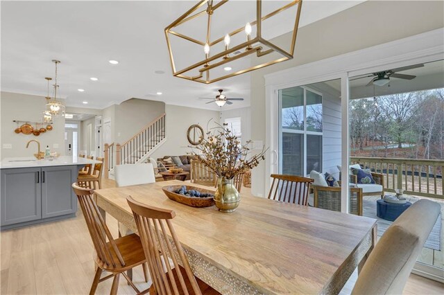 kitchen featuring sink, hanging light fixtures, gray cabinets, dishwasher, and an island with sink