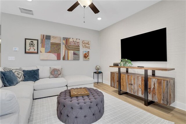 living room with ceiling fan and light hardwood / wood-style floors