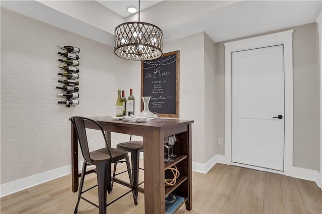 dining room featuring bar, light hardwood / wood-style floors, and a notable chandelier