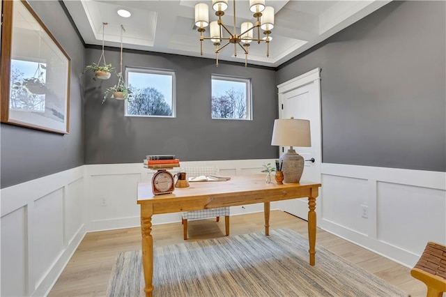 office space with coffered ceiling, a chandelier, beam ceiling, and light wood-type flooring