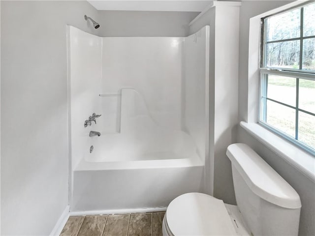 bathroom featuring shower / tub combination and toilet