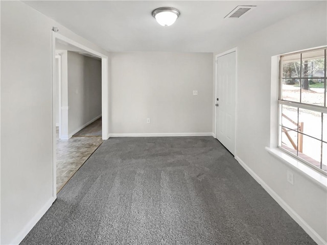 empty room with dark carpet and a healthy amount of sunlight