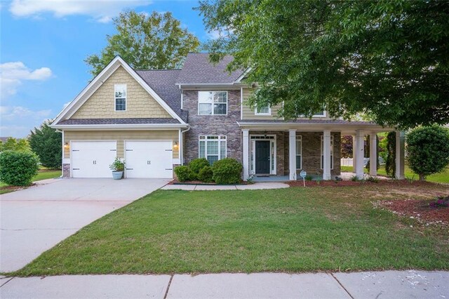 view of front facade with a garage, covered porch, and a front lawn