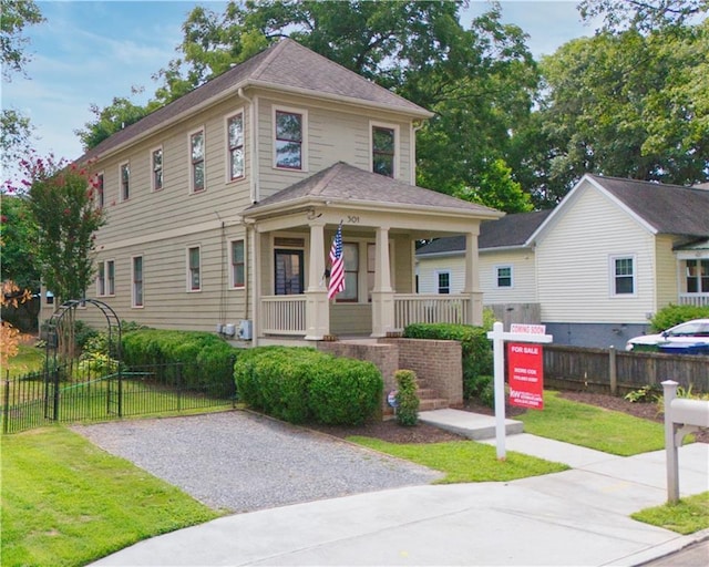 view of front of house featuring a porch, a front yard, and fence