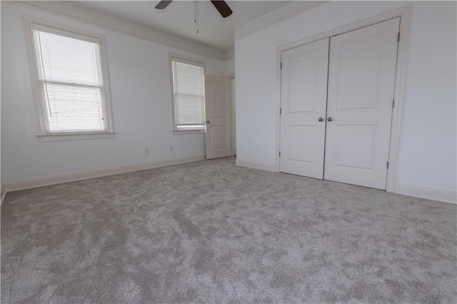 unfurnished bedroom with a closet, carpet flooring, ceiling fan, and baseboards