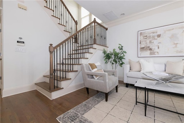 living area with stairway, wood finished floors, baseboards, and ornamental molding