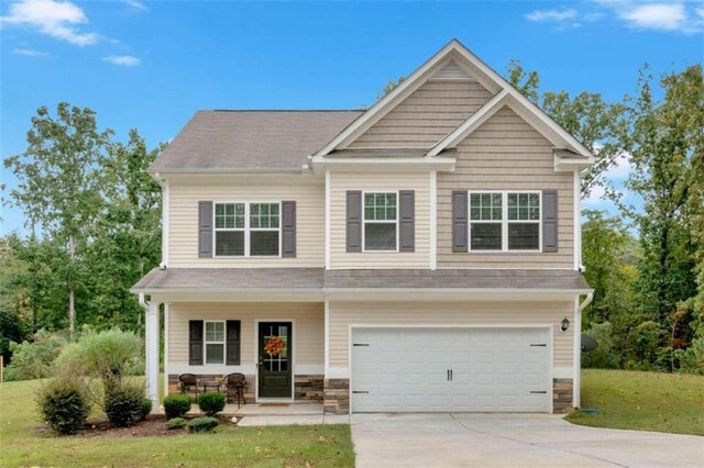 craftsman inspired home with a front yard, a garage, and covered porch