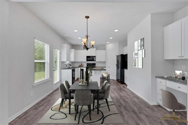 dining room with a chandelier, hardwood / wood-style flooring, and sink