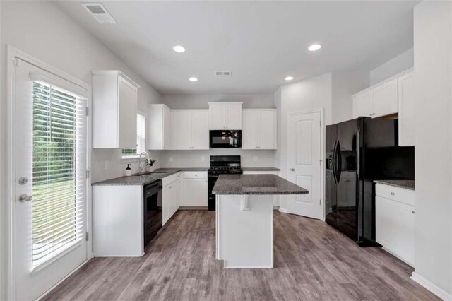 kitchen featuring a kitchen island, a wealth of natural light, sink, and black appliances