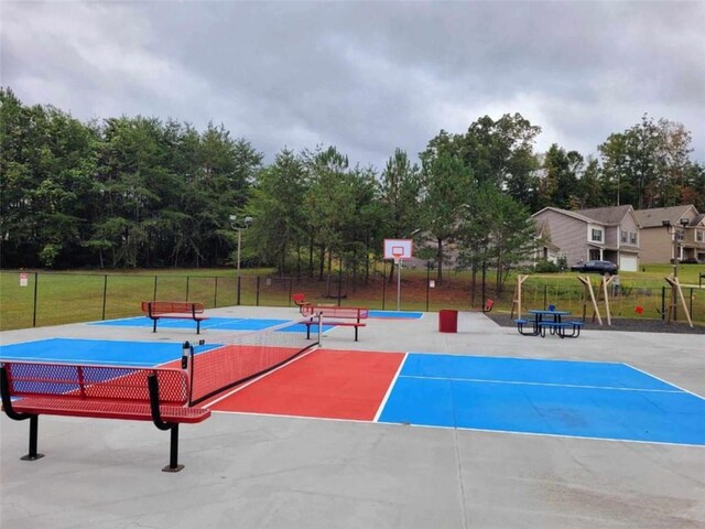 view of tennis court featuring basketball court and a yard