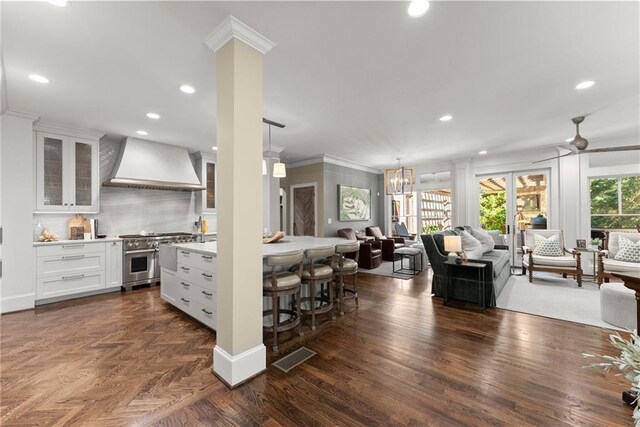 1539 Berkeley Ct, Gainesville, GA 30501 - kitchen featuring custom exhaust hood, high end stainless steel range, crown molding, light countertops, and a breakfast bar