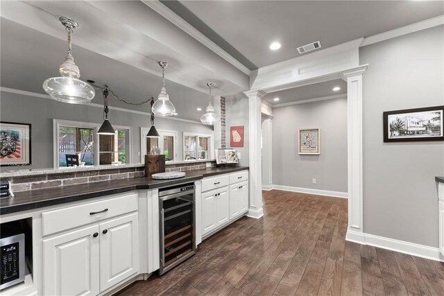 1539 Berkeley Ct, Gainesville, GA 30501 - kitchen with beverage cooler, crown molding, dark countertops, decorative backsplash, and ornate columns